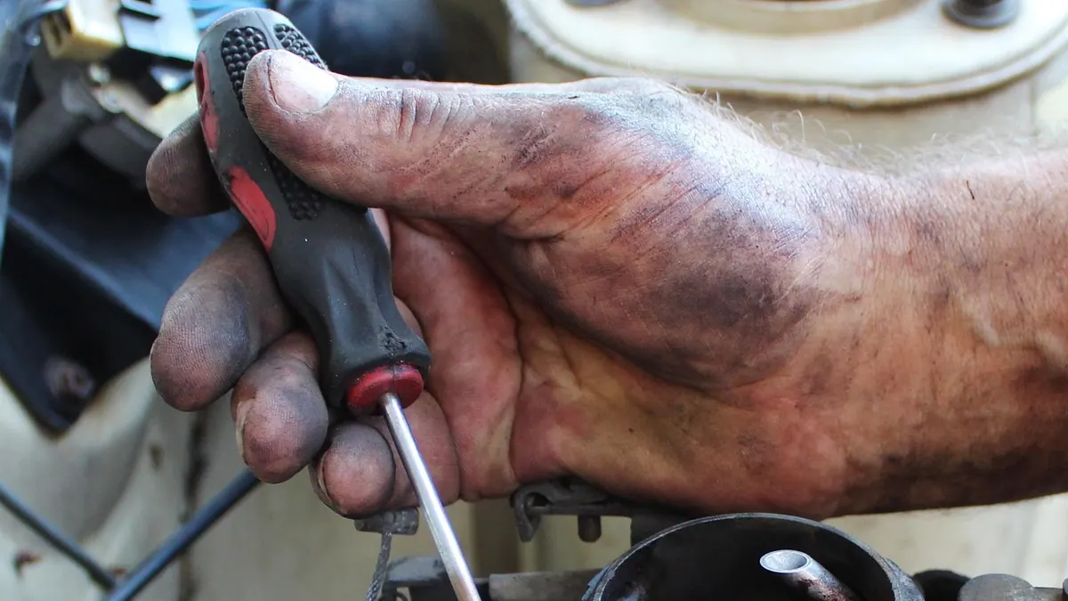 Mains d’un mécanicien sur un moteur